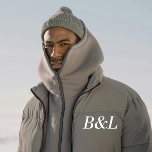 Mannequin portant la doudoune matelassée grise B&L avec sweat à capuche assorti et bonnet gris dans un paysage de neige - Streetwear Hiver."